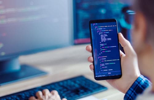 Handy mit Software-Code zur Darstellung von App Entwicklung