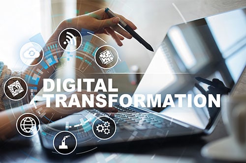 Digital-Transformation Hand zeigt auf Notebook darüber steht Digital Transformation.