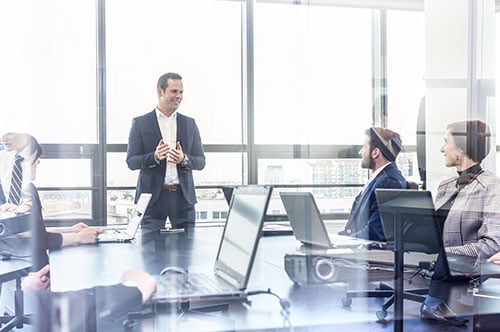 Mitarbeiter erklärt drei weiteren Mitarbeitern etwas im Management Training.